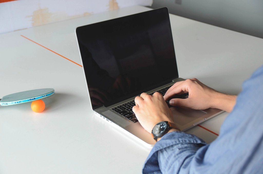 Manos escribiendo en el teclado de una laptop